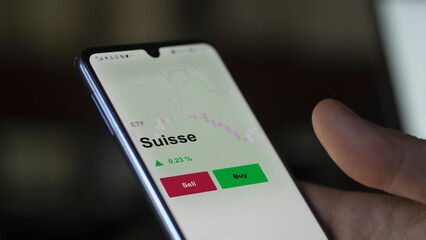 Un investisseur analyse un fonds etf suisse sur un graphique. Un téléphone affiche le cours de l'ETF. Texte en français francais Suisse