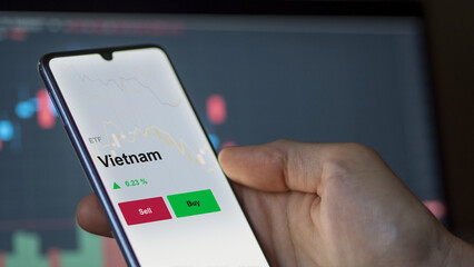 Un investisseur analyse un fonds etf vietnam sur un graphique. Un téléphone affiche le cours de l'ETF. Texte en français francais Vietnam