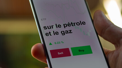 Un investisseur analyse un fonds etf sur le pétrole et le gaz sur un graphique. Un téléphone affiche le cours de l'ETF. Texte en français francais sur le pétrole et le gaz
