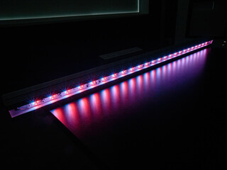 Pink and purple LED lamp for greenhouse on the table, close up