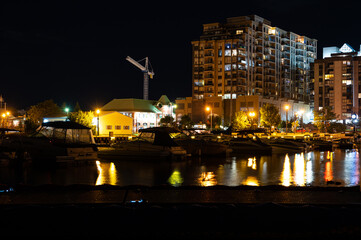 Naklejka premium centennial beach barrie at night time building lights boat yard all in view 