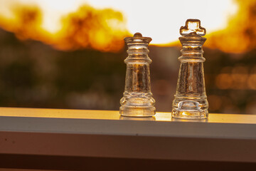 Szklane figury szachowe zbliżenie, w tle zachód słońca. 