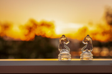 Szklane figury szachowe zbliżenie, w tle zachód słońca. 