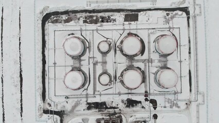 The drone flies around the oil storage tank, oil and gas reserves of Russia. Oil and gas industry in the world economy Flying over tanks in winter during a price increase crisis. Oil and gas reserves.