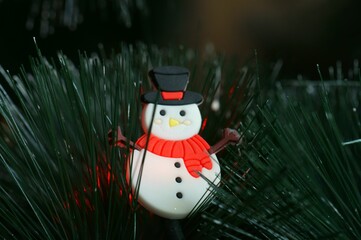 A toy snowman on a Christmas tree. Festive decorations.