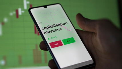 Un investisseur analyse un fonds etf capitalisation moyenne sur un graphique. Un téléphone affiche le cours de l'ETF. Texte en français francais capitalisation moyenne