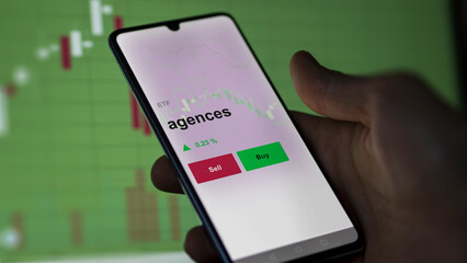 Un investisseur analyse un fonds etf agences sur un graphique. Un téléphone affiche le cours de l'ETF. Texte en français francais agences