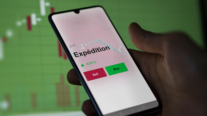 Un investisseur analyse un fonds etf expédition sur un graphique. Un téléphone affiche le cours de l'ETF livraison et fret. Texte en français francais