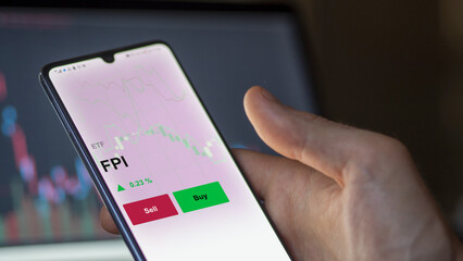 Un investisseur analyse un fonds etf fpi sur un graphique. Un téléphone affiche le cours de l'ETF. Texte en français francais FPI