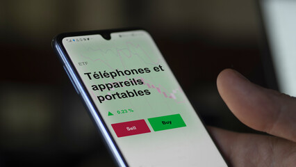 Un investisseur analyse un fonds etf téléphones et appareils portables sur un graphique. Un téléphone affiche le cours de l'ETF. Texte en français francais Téléphones et appareils portables