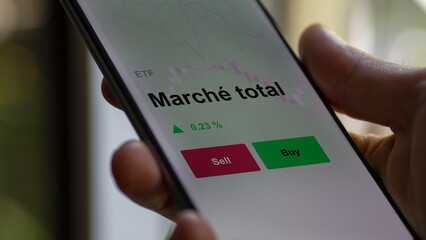 Un investisseur analyse un fonds etf marché total sur un graphique. Un téléphone affiche le cours de l'ETF. Texte en français francais Marché total