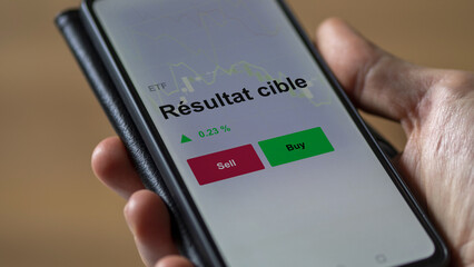Un investisseur analyse un fonds etf résultat cible sur un graphique. Un téléphone affiche le cours de l'ETF. Texte en français francais Résultat cible