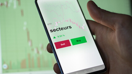 Un investisseur analyse un fonds etf secteurs sur un graphique. Un téléphone affiche le cours de l'ETF. Texte en français francais secteurs