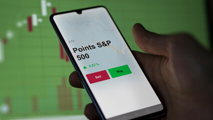 Un investisseur analyse un fonds etf points s&p 500 sur un graphique. Un téléphone affiche le cours de l'ETF. Texte en français francais Points S&P 500