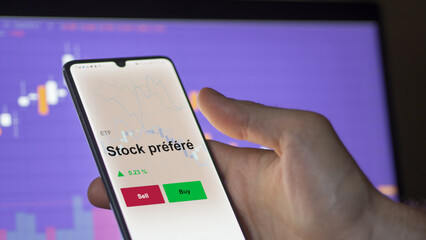 Un investisseur analyse un fonds etf stock préféré sur un graphique. Un téléphone affiche le cours de l'ETF. Texte en français francais Stock préféré