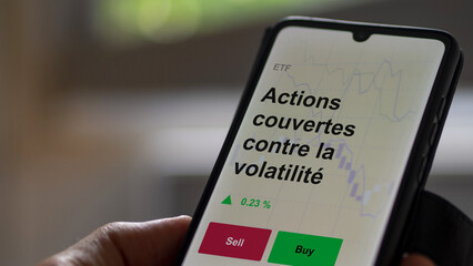 Un investisseur analyse un fonds etf actions couvertes contre la volatilité sur un graphique. Un téléphone affiche le cours de l'ETF. Texte en français francais Actions couvertes contre la volatilité