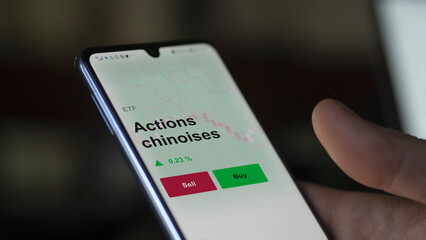 Un investisseur analyse un fonds etf actions chinoises sur un graphique. Un téléphone affiche le cours de l'ETF. Texte en français francais Actions chinoises