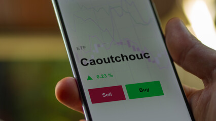 Un investisseur analyse un fonds etf caoutchouc sur un graphique. Un téléphone affiche le cours de l'ETF. Texte en français francais Caoutchouc