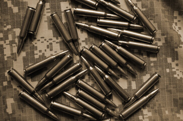 Rifle cartridges on a camouflage background. Top view. Sepia