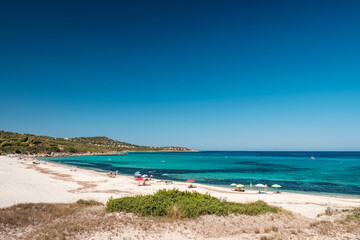 Fototapeta na wymiar Holidaymakers enjoy the turquoise Mediterranean sea at Bodri beach in the Balagne region of Corsica