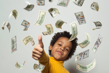 Adorable kid young boy in the rain of money on white background