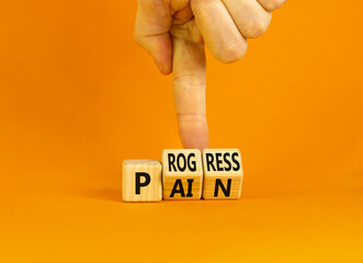 Pain or progress symbol. Concept words Pain or Progress on wooden cubes. Businessman hand. Beautiful orange table orange background. Business and pain or progress concept. Copy space.