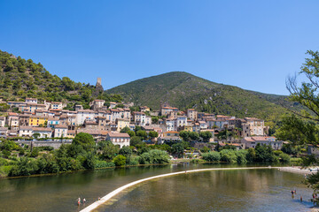 Fototapeta na wymiar Vue estivale sur le village de Roquebrun depuis le pont traversant l'Orb