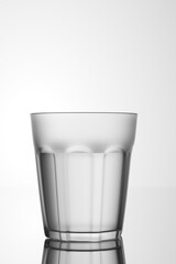 Faceted glass filled with water on a white background. 3d render.