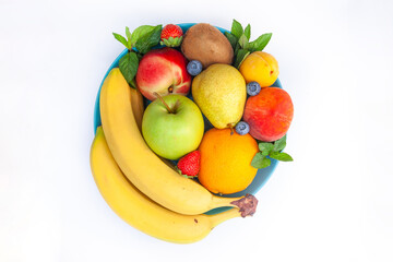 Bright juicy fruits laid out in a plate - blueberries, bananas, pears, apples, mint