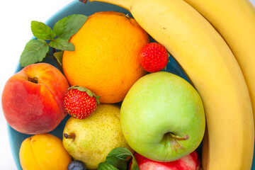 Bright juicy fruits laid out in a plate - blueberries, bananas, pears, apples, mint
