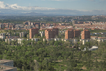 Fototapeta na wymiar view of one of the neighborhoods of Madrid with modern buildings and in the background the mountains of the Sierra de Guadarrama