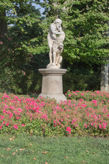 sculpture of old man with ram surrounded by flowers in the Retiro park in Madrid
