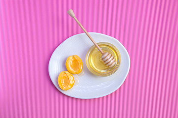 Apricots with honey and wooden honey spoon 
