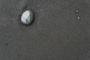 Icelandic black sand. Background, pattern, volcanic black sea sand.