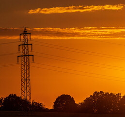 power pole on a field in sunset