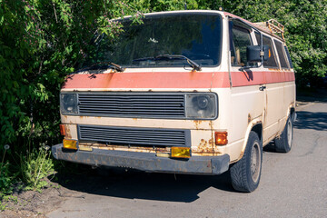 an old vintage rusty minibus standing in the yard. hippie culture