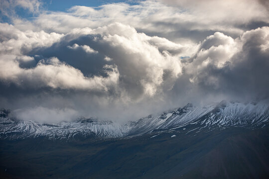 View of snowy mountains and thick clouds