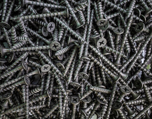 the background consists of a pile of black screws. the concept of construction and repair
