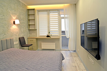 Bedroom with decorative window lighting and TV on the wall