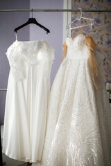 Two wedding dresses hanging on a hanger