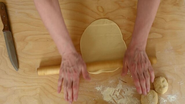 Overhead view of woman rolling thin pastry dough. Process of cooking khistibiy - traditional tatar cuisine dish