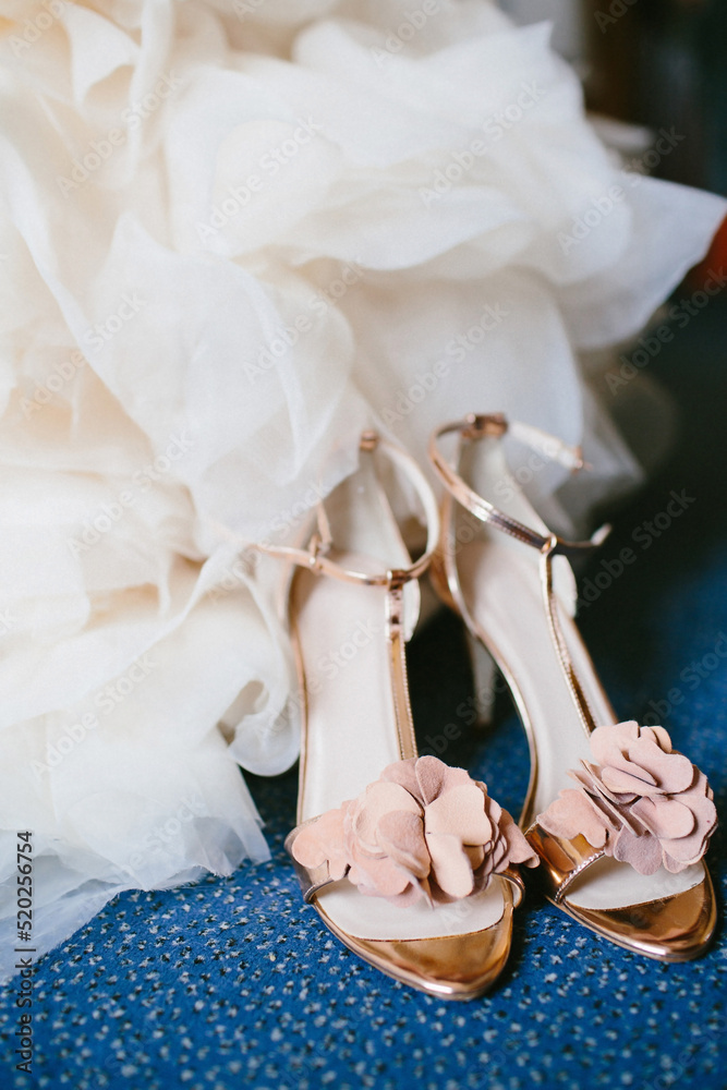 Wall mural Pink shoes on the floor near the wedding dress