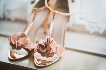 Pink wedding shoes on a wooden windowsill