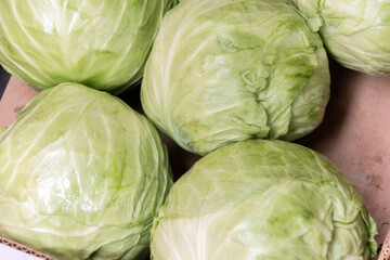 Fototapeta premium Fresh heads of cabbage close-up. Sale of vegetables at the farmers market.