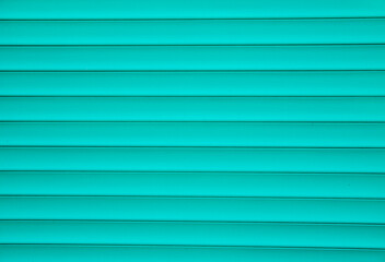 Abstract metal background of their shutters. Blue shutters on the door. Smooth horizontal lines. Texture of metal strips.