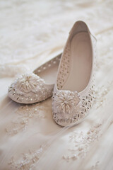 Fototapeta na wymiar White shoes lie on a wedding dress