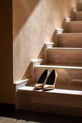 Beige wedding shoes stand on stone staircase