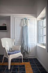 Wedding dress on the wardrobe and shoes on the chair