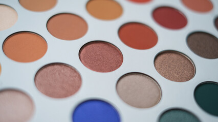 Selective focus of eyeshadow palette with various colors in pearly and matte closeup