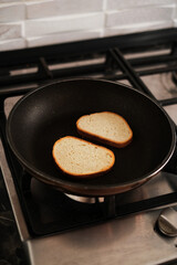 bread is fried in a pan on a gas stove